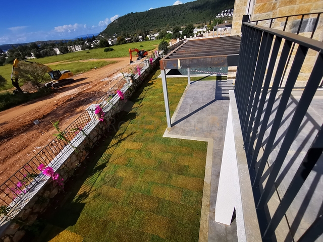 Villen in der malerischen Gegend von Turkbükü, umgeben von dichtem Grün. 