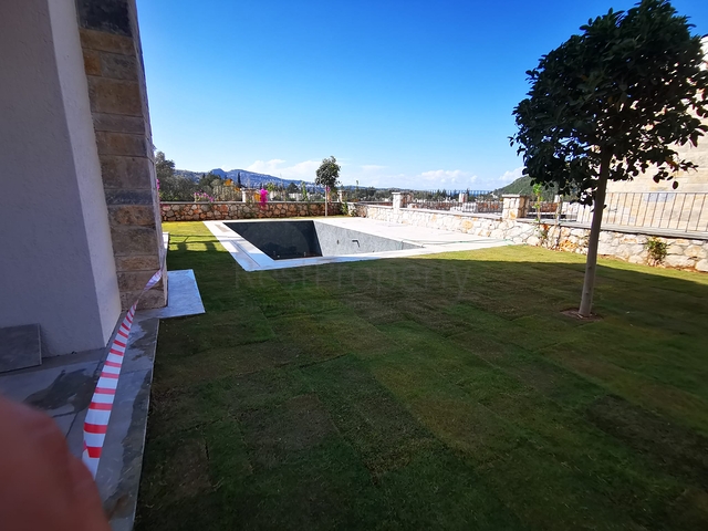 Villen in der malerischen Gegend von Turkbükü, umgeben von dichtem Grün. 